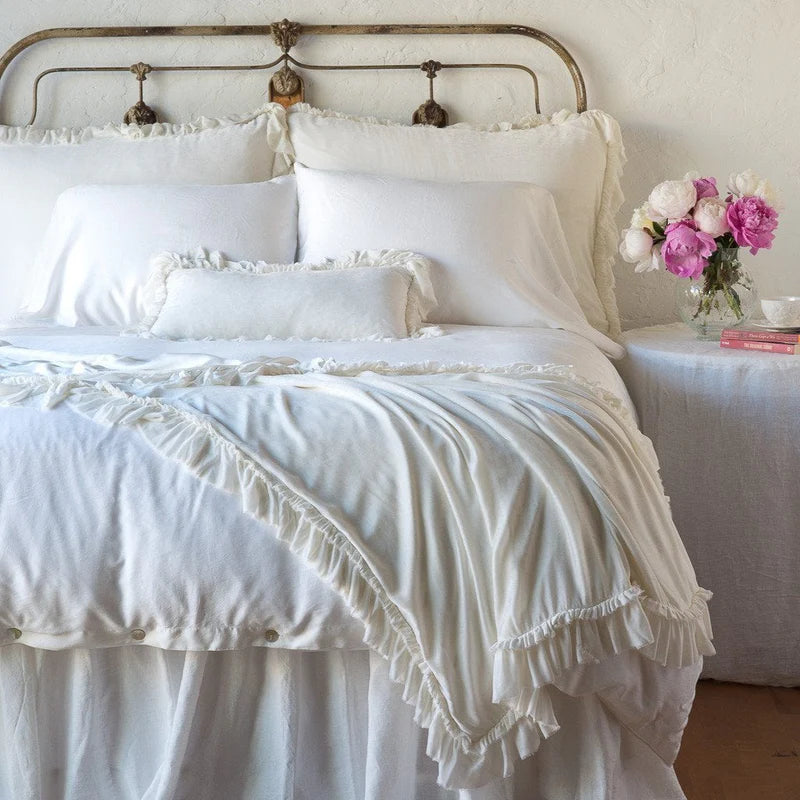 Bella Notte Loulah Throw Blanket in autumn colors, soft and cozy fabric, displayed draped on a bed for a warm, inviting look.