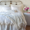 Bella Notte Loulah Throw Blanket in autumn colors, soft and cozy fabric, displayed draped on a bed for a warm, inviting look.