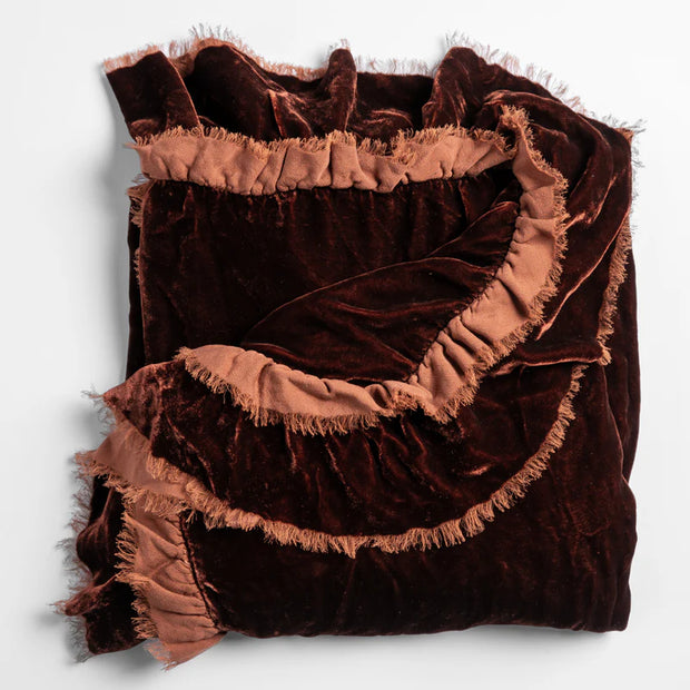Bella Notte Loulah throw blanket in warm autumn tones, soft and cozy fabric, draped over a stylish living room sofa.