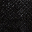 Bella Notte silk velvet quilted throw blanket draped over a sofa, showcasing its luxurious texture and rich autumn colors.