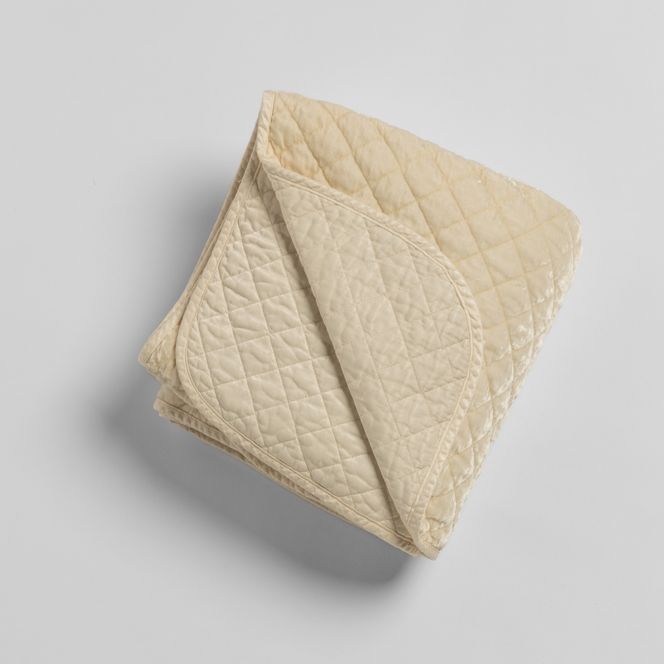 Cream silk velvet quilted throw blanket by Bella Notte, soft and luxurious with a plush quilted pattern.