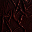 Bella Notte Loulah throw pillow featuring soft autumn-colored fabric and decorative bolster design.