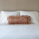 Bella Notte Loulah throw pillow with autumn-colored fabric and decorative bolster design on soft, textured fabric.