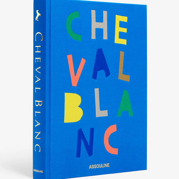 Blue book titled 'Cheval Blanc' with colorful text on a white background