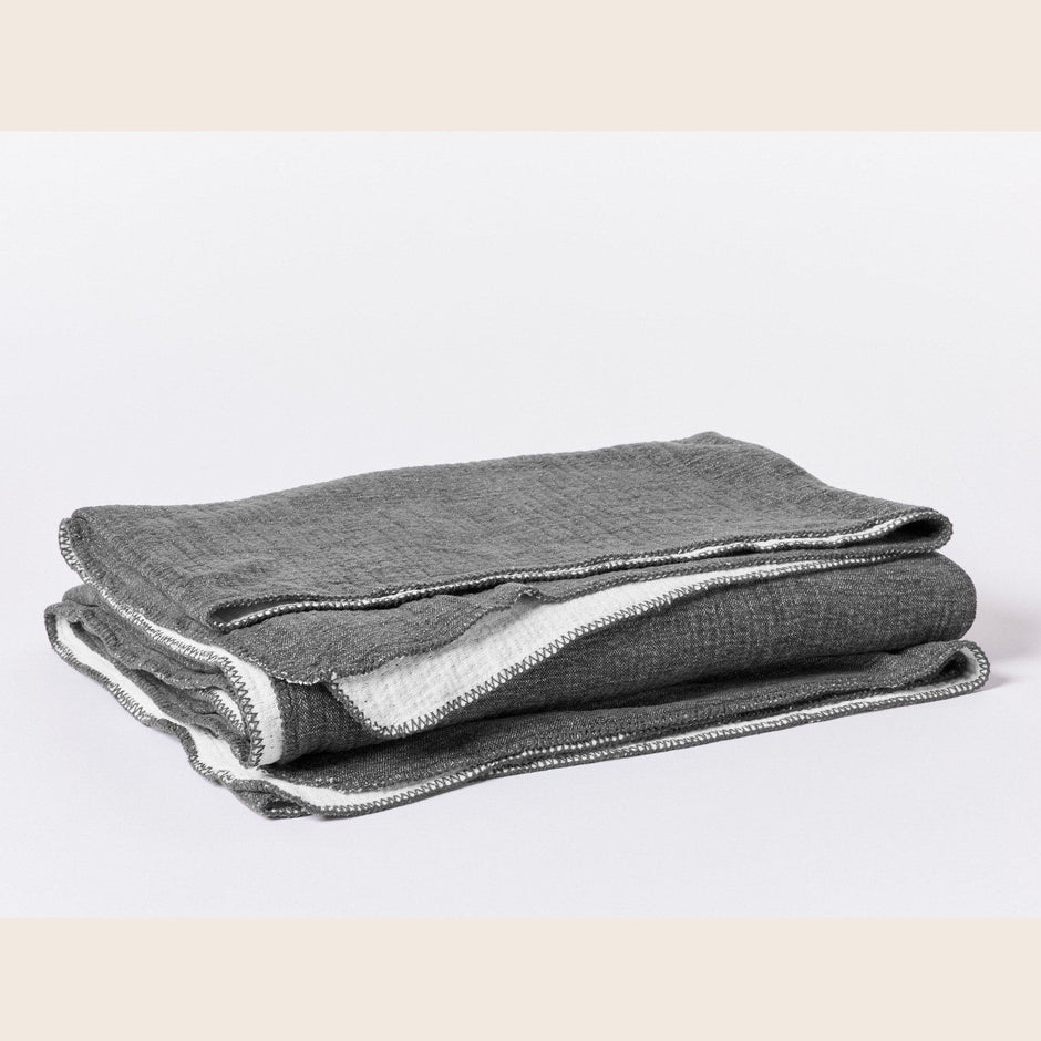 Coyuchi organic cotton blanket in charcoal for king size bed, soft and cozy bedding made from natural cotton.