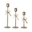 Set of three antique gold bow taper holders by Creative Co-op, featuring elegant bow design for decorative candle display.