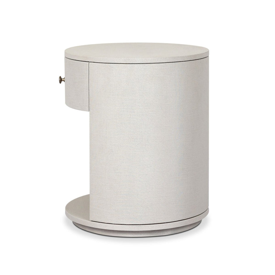 Four Hands Amelia oval nightstand with one drawer in ivory linen, showcasing a sleek modern design and smooth surface.