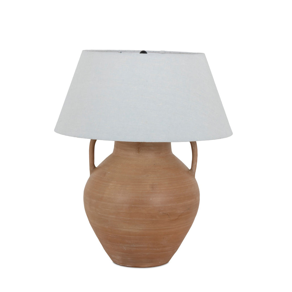 Atrani table lamp by Four Hands featuring a sleek design with a neutral lampshade and modern base for stylish illumination.