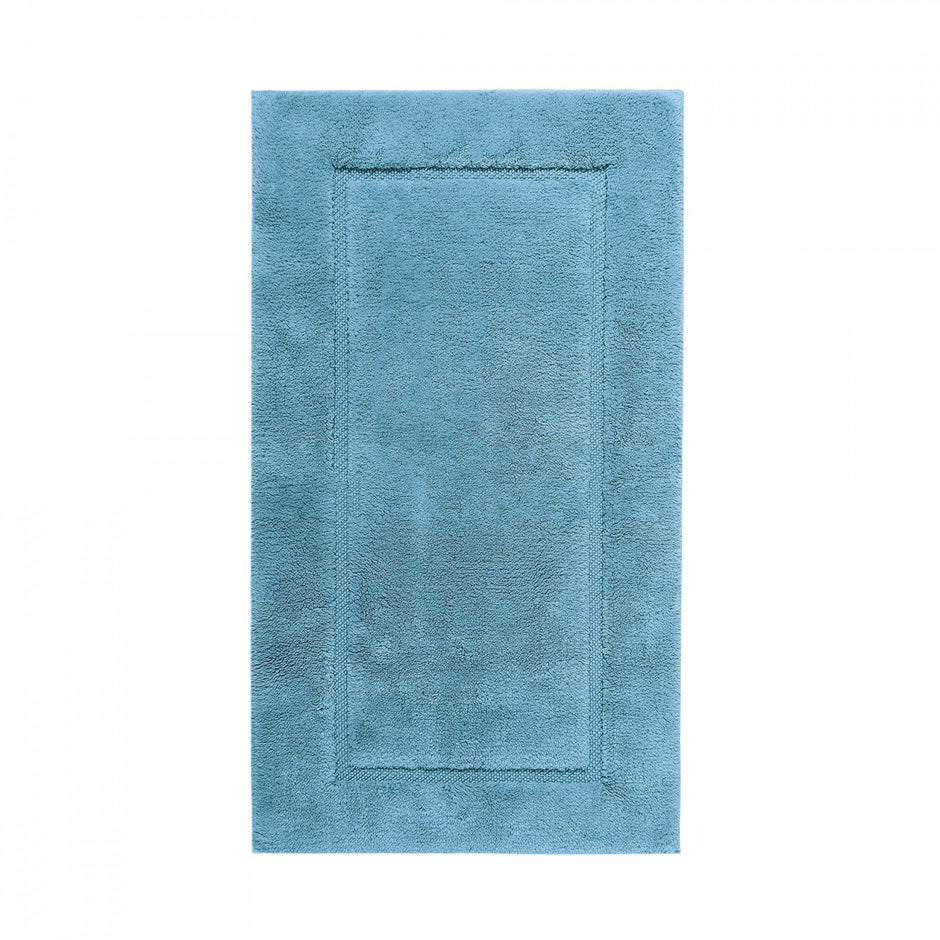 Graccioza Egoist bath rug in beige, 28x47 inches, plush and absorbent, placed on a bathroom floor with soft lighting.