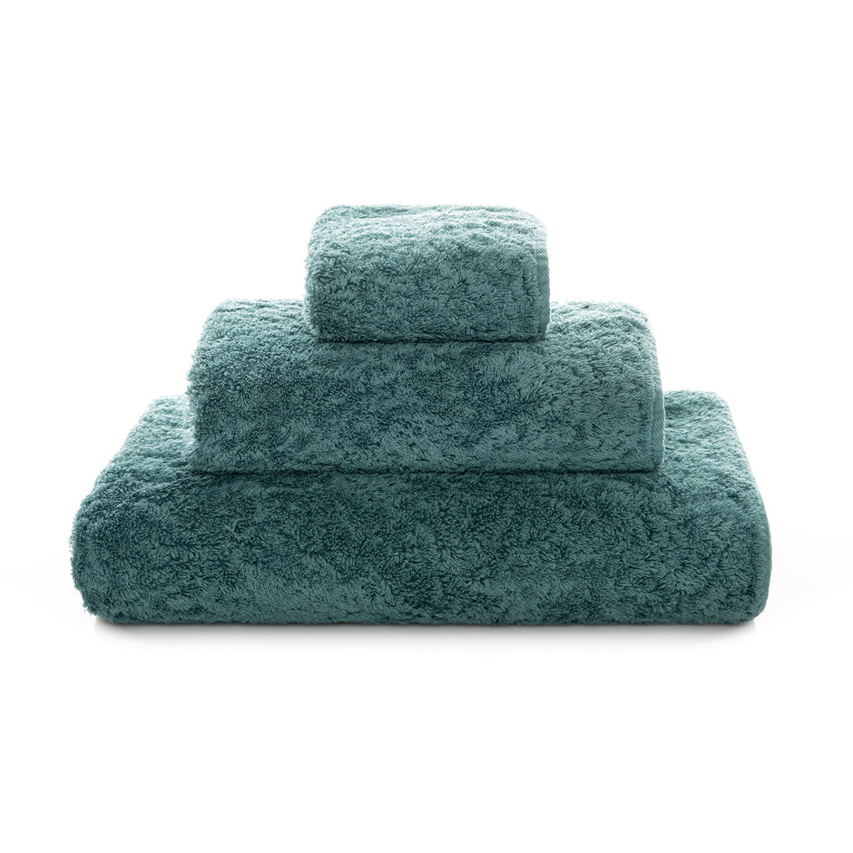 Graccioza Egoist hand towel in white with plush, textured fabric, displayed folded on a clean bathroom countertop.