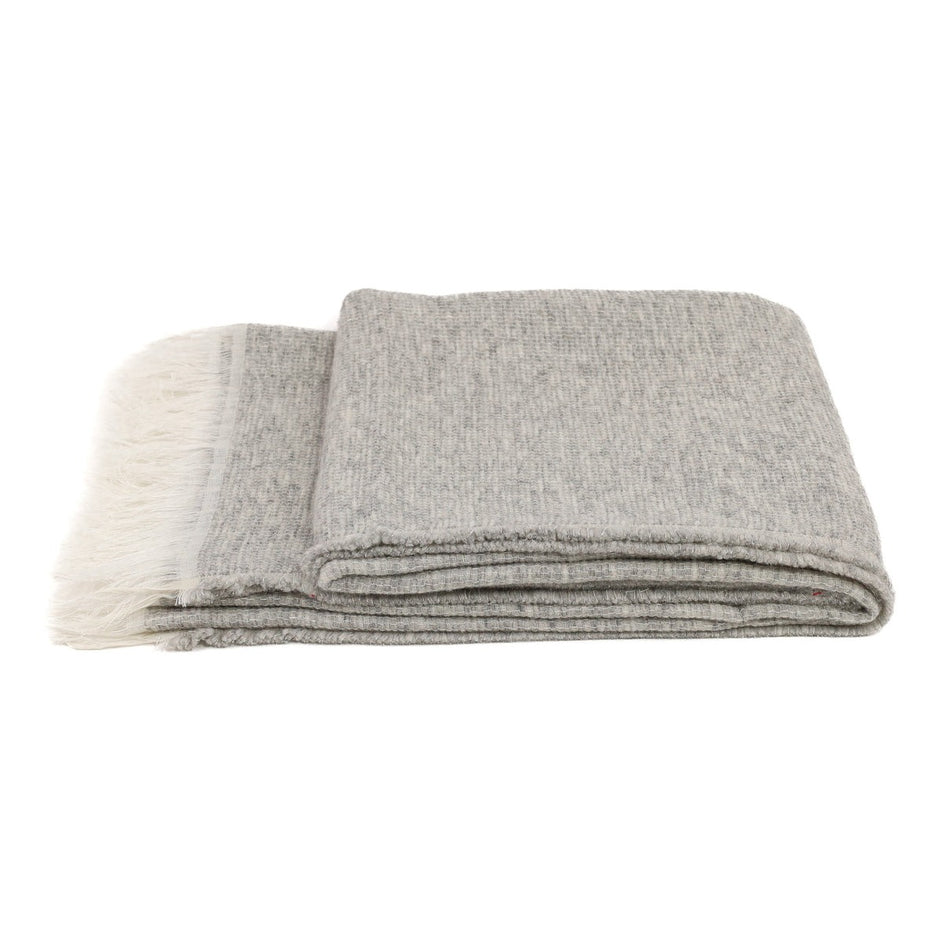 White Uniq'uity Allen throw blanket showing soft fabric and simple design, perfect for cozy home decor.