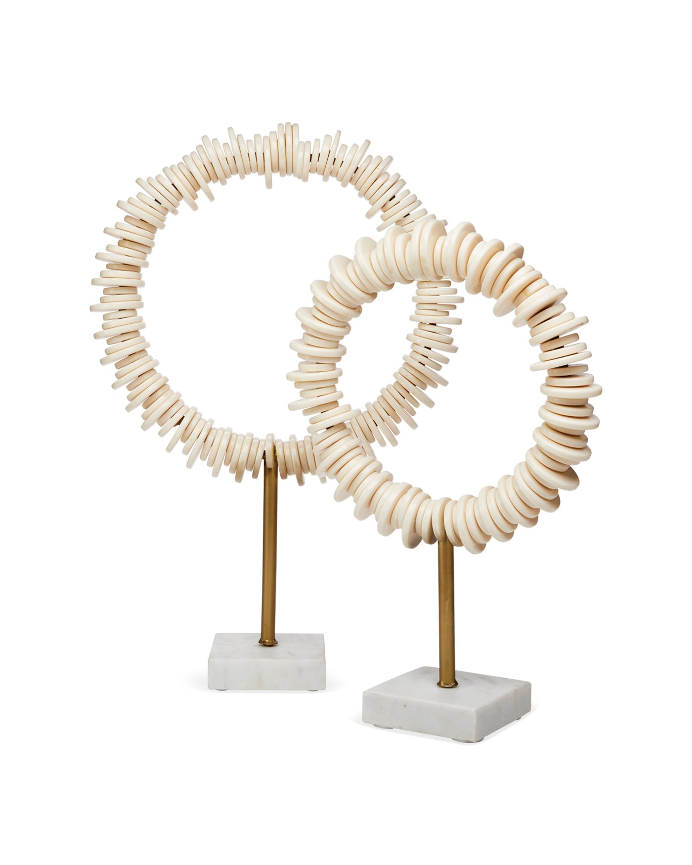 Two decorative circular sculptures made of stacked natural wood discs on slender brass stands with square white marble bases, photographed against a clean white background.