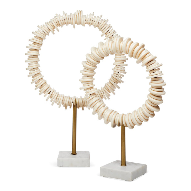Two decorative circular sculptures made of stacked natural wood discs on slender brass stands with square white marble bases, photographed against a clean white background.