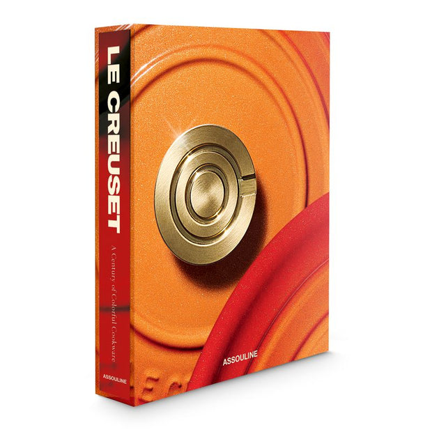 Le Creuset decor book with a gold handle on an orange background