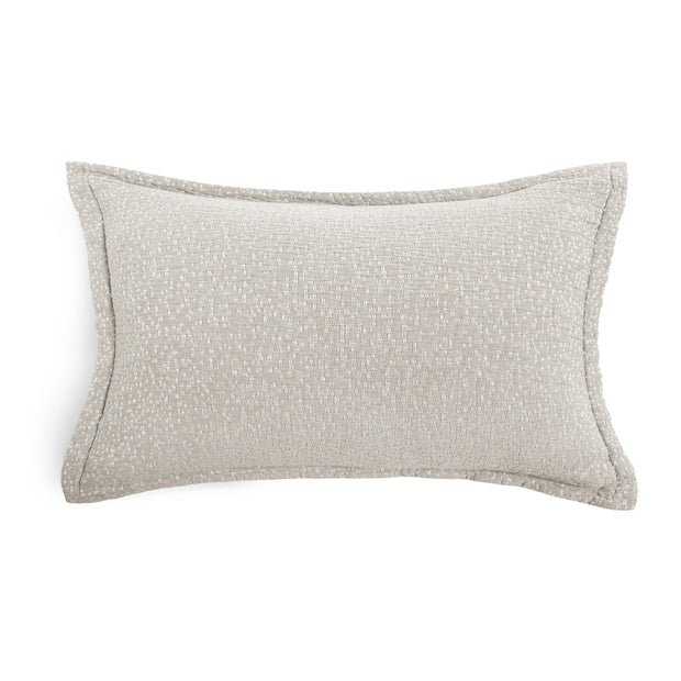 A rectangular lumbar throw pillow in a textured light beige fabric with piped edges, shown on a plain white background.