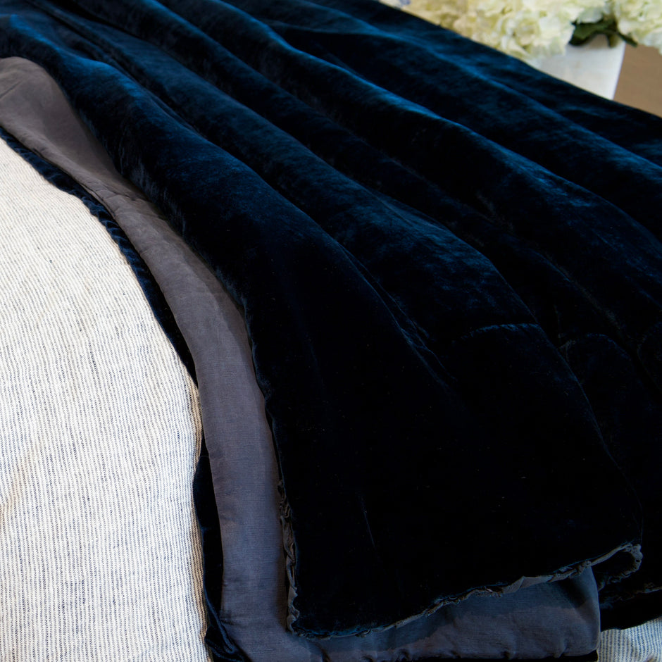 Dark blue textured blanket draped over a light-colored couch