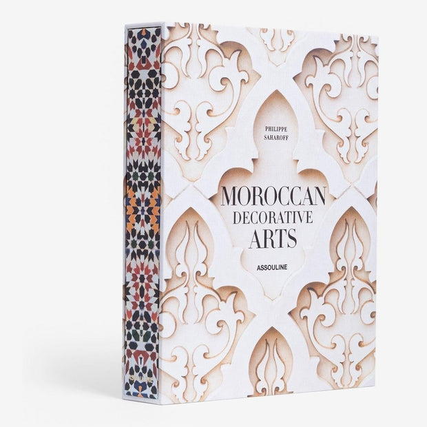 A book titled 'Moroccan Decorative Arts' by Assouline, with a geometric patterned cover in brown and white.