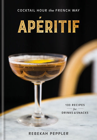 Apertif in a glass with a bottle of Penguin Random House LLC aperitif on a table, served with ice and garnishes.