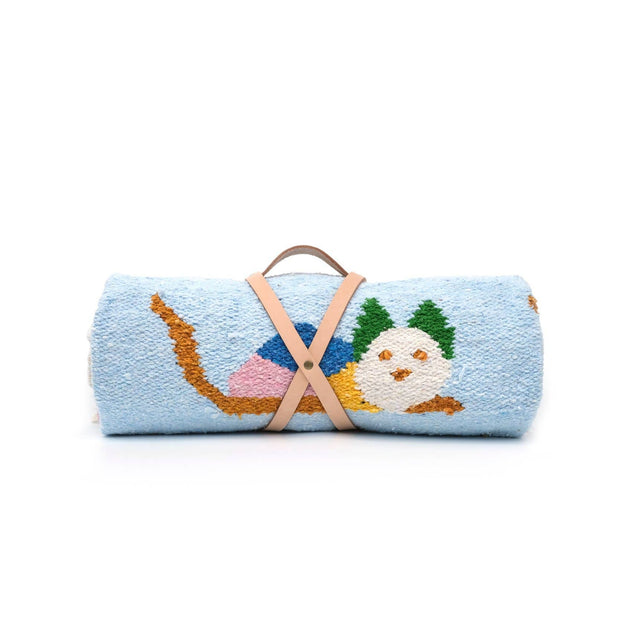 Roll of blue fabric with embroidered design on a white background