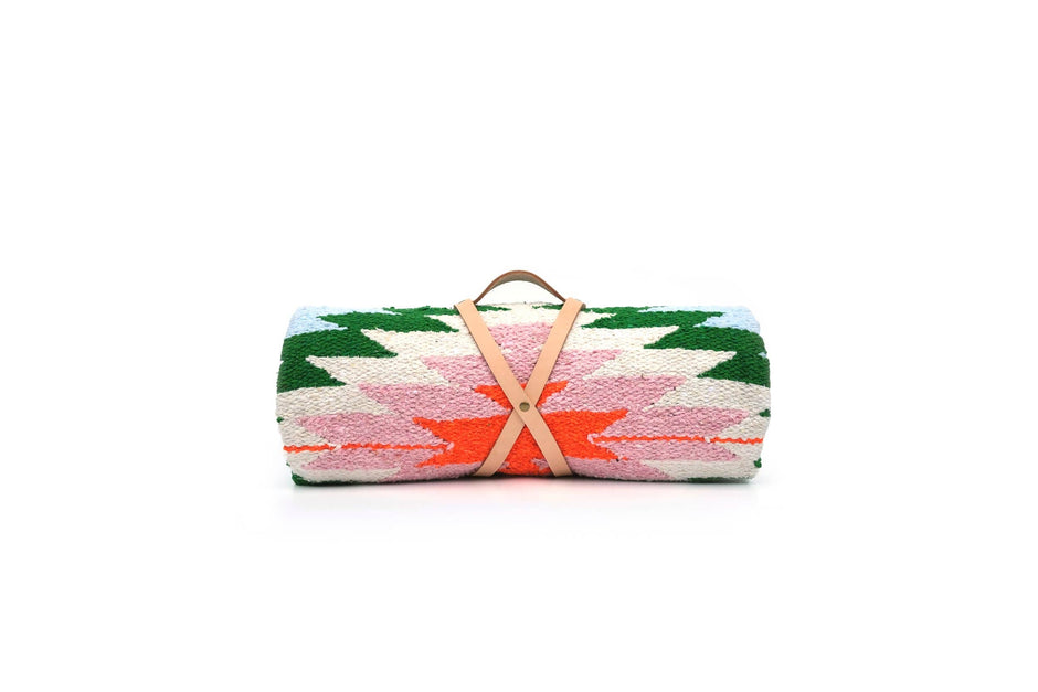 Colorful woven blanket with a handle on a white background