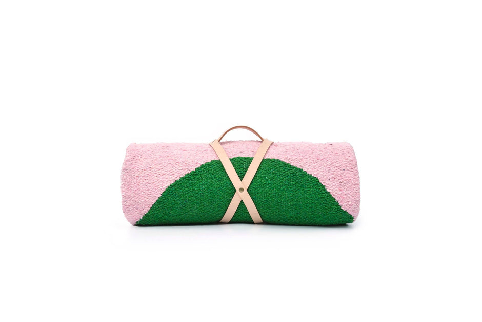 Pink and green clutch bag with a beige strap on a white background
