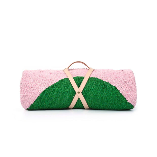 Pink and green clutch bag with a beige strap on a white background