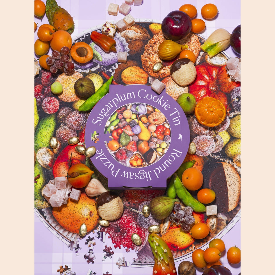 Specialty Puzzle Sugarplum Cookie Tin by Piecework, featuring festive tin with colorful sugarplum cookies and holiday design.