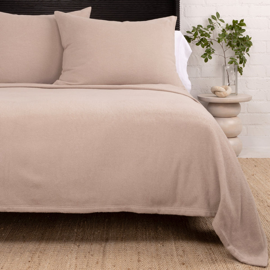 Ivory Pom Pom at Home Billie Blanket, cozy knit throw with pom pom accents, displayed folded on a neutral background.