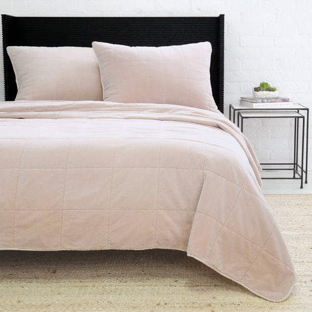 Blush Pom Pom at Home Amsterdam coverlet on a bed, showing soft fabric and decorative pom pom trim for a cozy bedroom look.