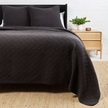 Pom Pom at Home Huntington coverlet in midnight, showcasing soft fabric with decorative pom-pom accents on bed.