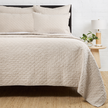 Navy Pom Pom at Home Hampton coverlet on a bed, showcasing soft fabric and decorative pom pom edges for a cozy bedroom look.