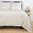 Navy Pom Pom at Home Hampton coverlet on a bed, showcasing a soft, textured fabric with pom pom accents for a cozy bedroom look.