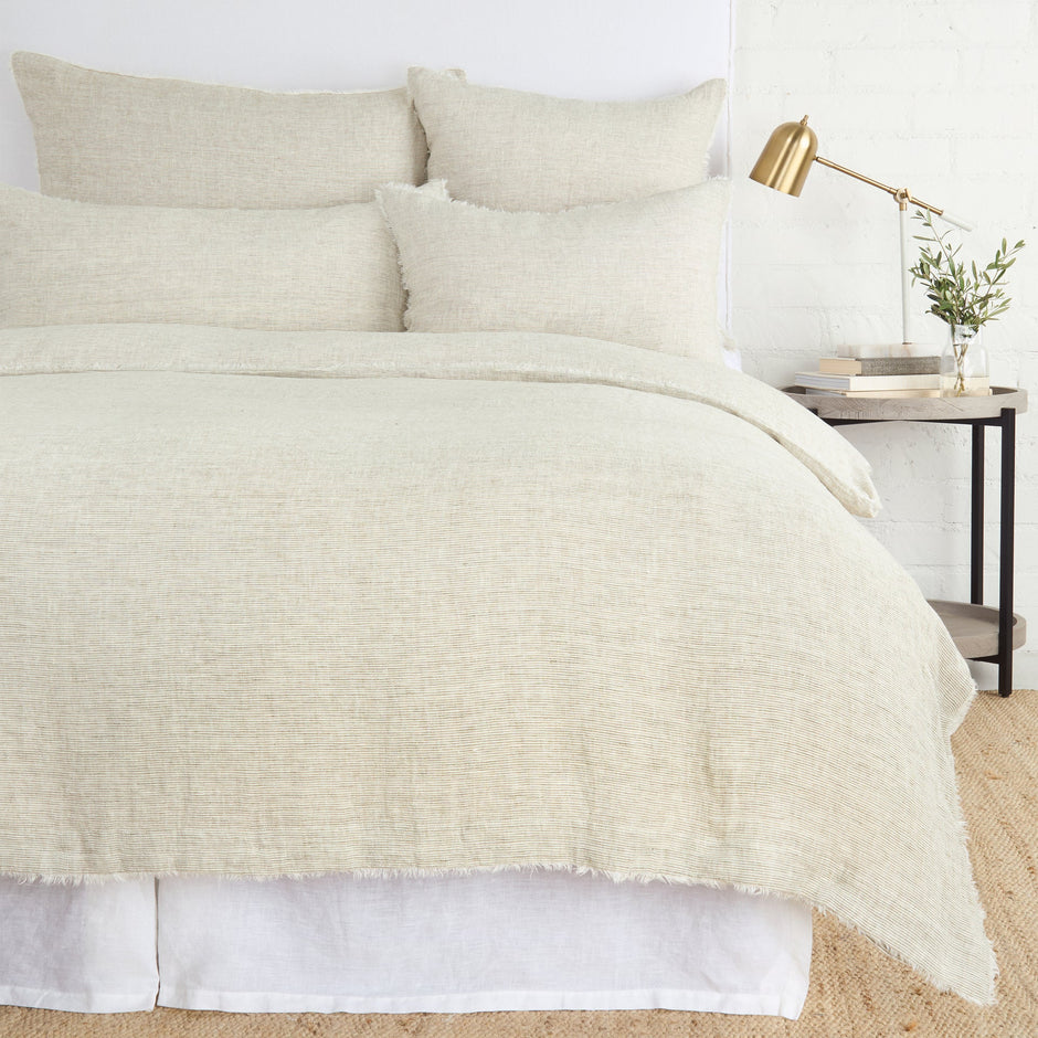 Navy Pom Pom at Home Logan duvet cover on a bed, showcasing soft fabric and decorative pom pom trim for a cozy bedroom look.