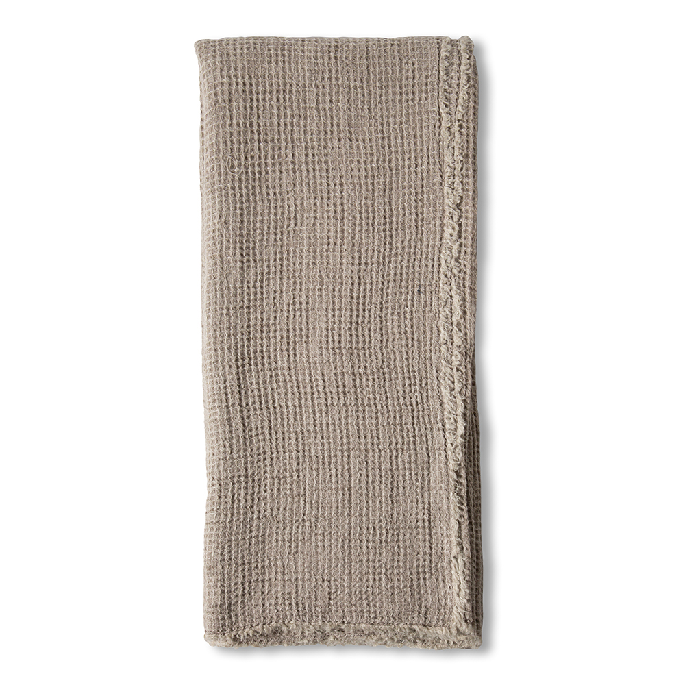 Taupe linen throw blanket by Pom Pom at Home with decorative pom-pom accents, perfect for cozy home decor.