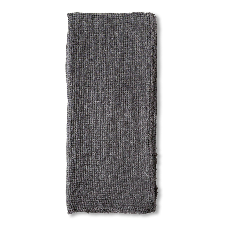 Taupe linen throw blanket from Pom Pom at Home with pom-pom accents, cozy and stylish for living room or bedroom decor.