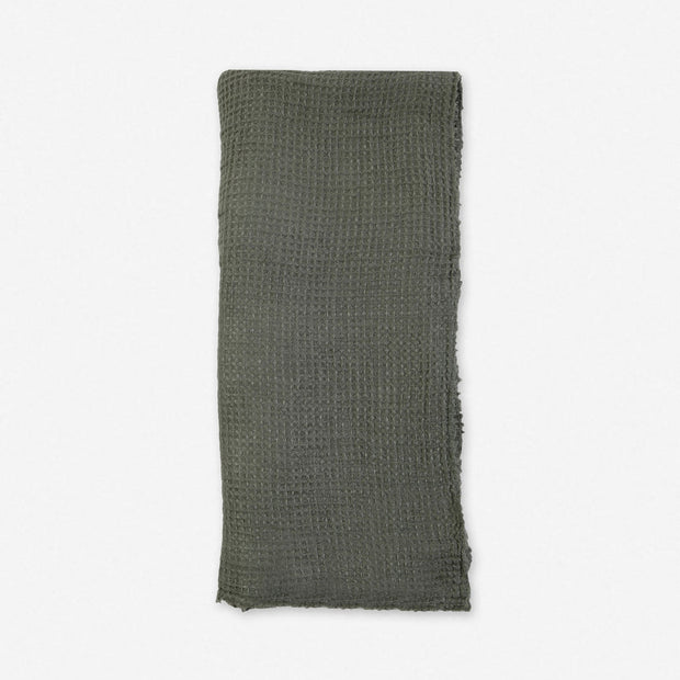 Taupe linen throw blanket from Pom Pom at Home with decorative pom-pom accents, cozy and stylish for living room or bedroom.