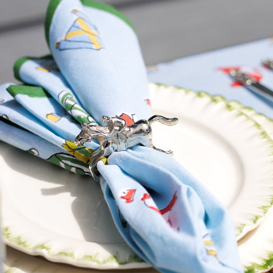 Set of four silver horse jockey napkin rings with vintage style, featuring detailed jockey figures on a decorative table setting.