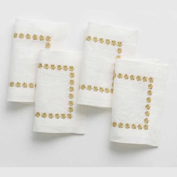 Set of four India Hicks gold stars cocktail napkins by Pomegranate, elegant table linens with star pattern for entertaining.