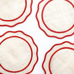 Set of four deep red woven rice paper placemats with scalloped edges from Pomegranate, ideal for elegant table settings.