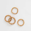 Set of four round bamboo napkin rings from Pomegranate, natural wood finish for elegant table linens and dining decor.