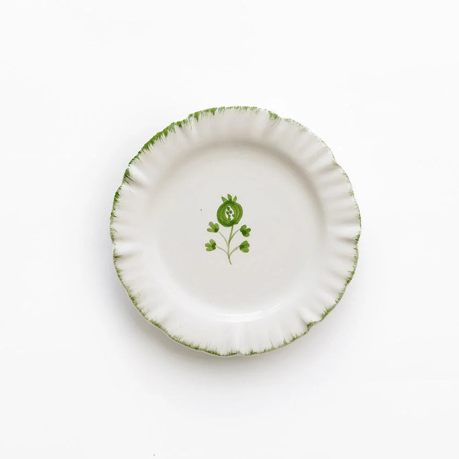Set of four Pomegranate ruffled appetizer plates with elegant linen table linens for serving small dishes.