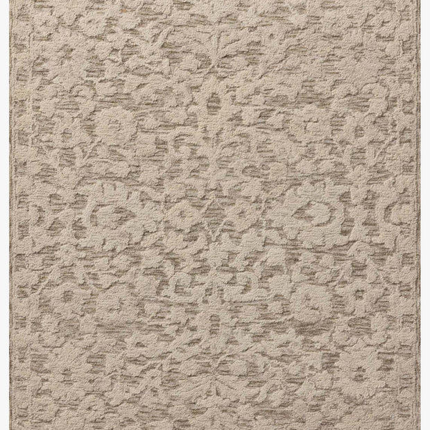 Textured beige rug with a subtle pattern on a white background