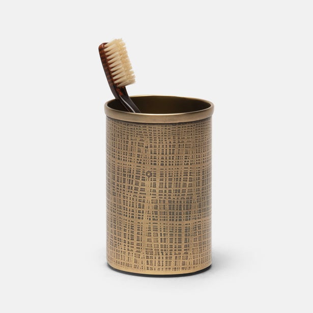 Textured brass toothbrush holder with a toothbrush on a white background