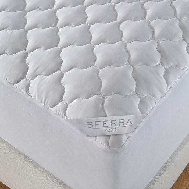 Sferra York King Mattress Pad with soft quilted surface and elastic edges for a secure fit on a king-size mattress.