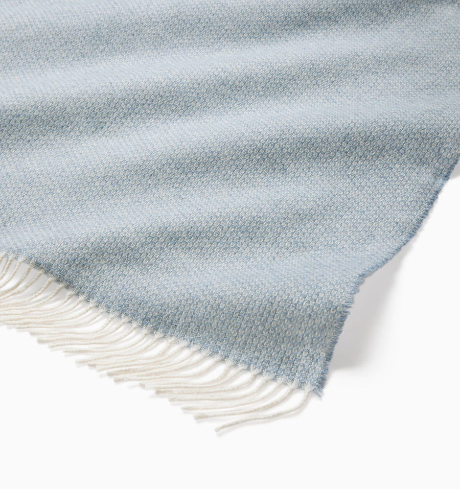Beige Sferra Cervino throw blanket with soft, woven fabric draped over a sofa for cozy comfort and elegant decor.