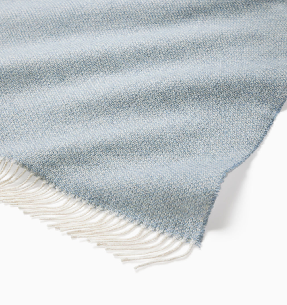 Beige Sferra Cervino throw blanket with soft, woven fabric draped over a sofa for cozy comfort and elegant decor.