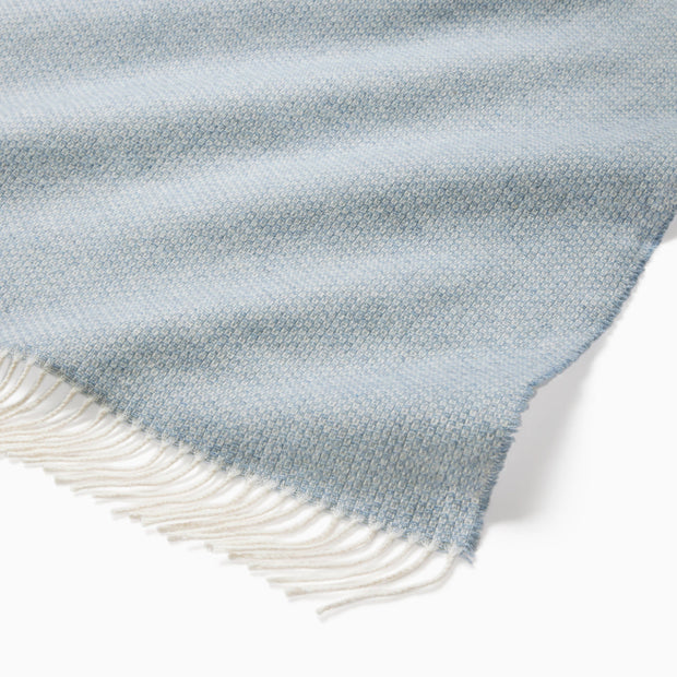 Beige Sferra Cervino throw blanket with soft, woven fabric draped over a sofa for cozy comfort and elegant decor.