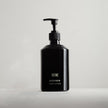 Tatine hand lotion bottle with pine and orange scent, featuring a sleek clear container and a white pump dispenser.