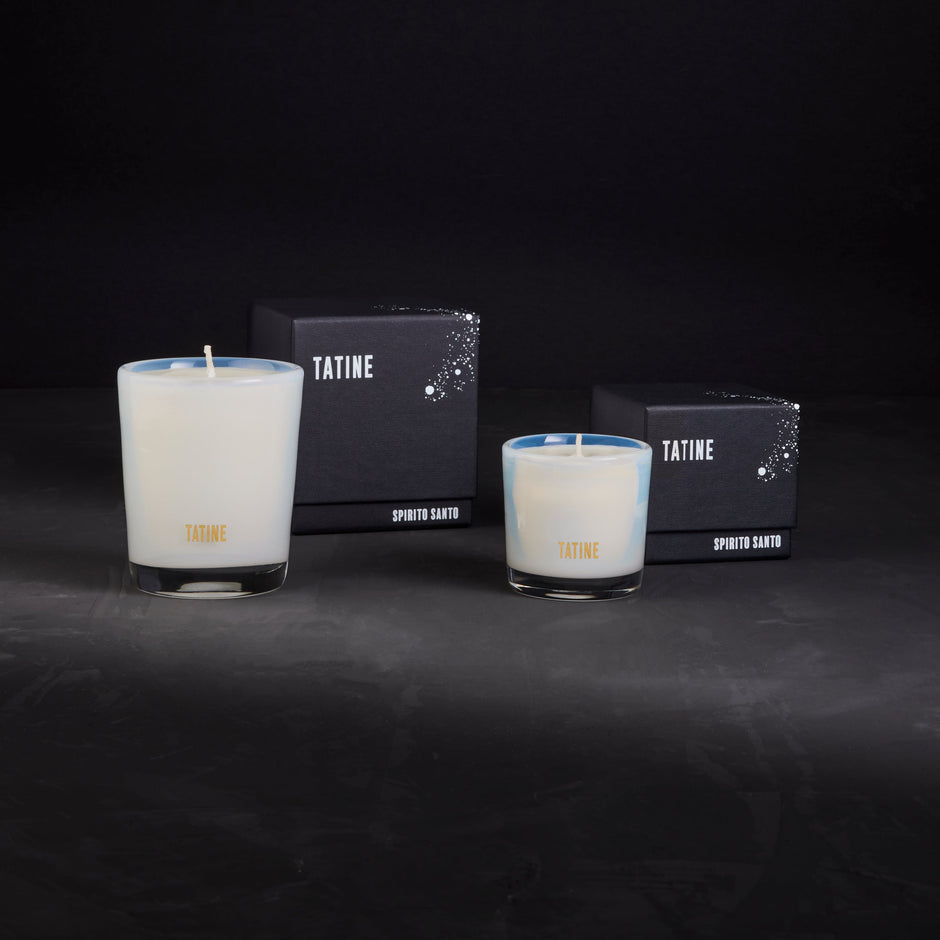Tatine Stars Are Fire Classic Scented Candle with a warm, inviting glow in a clear glass container.