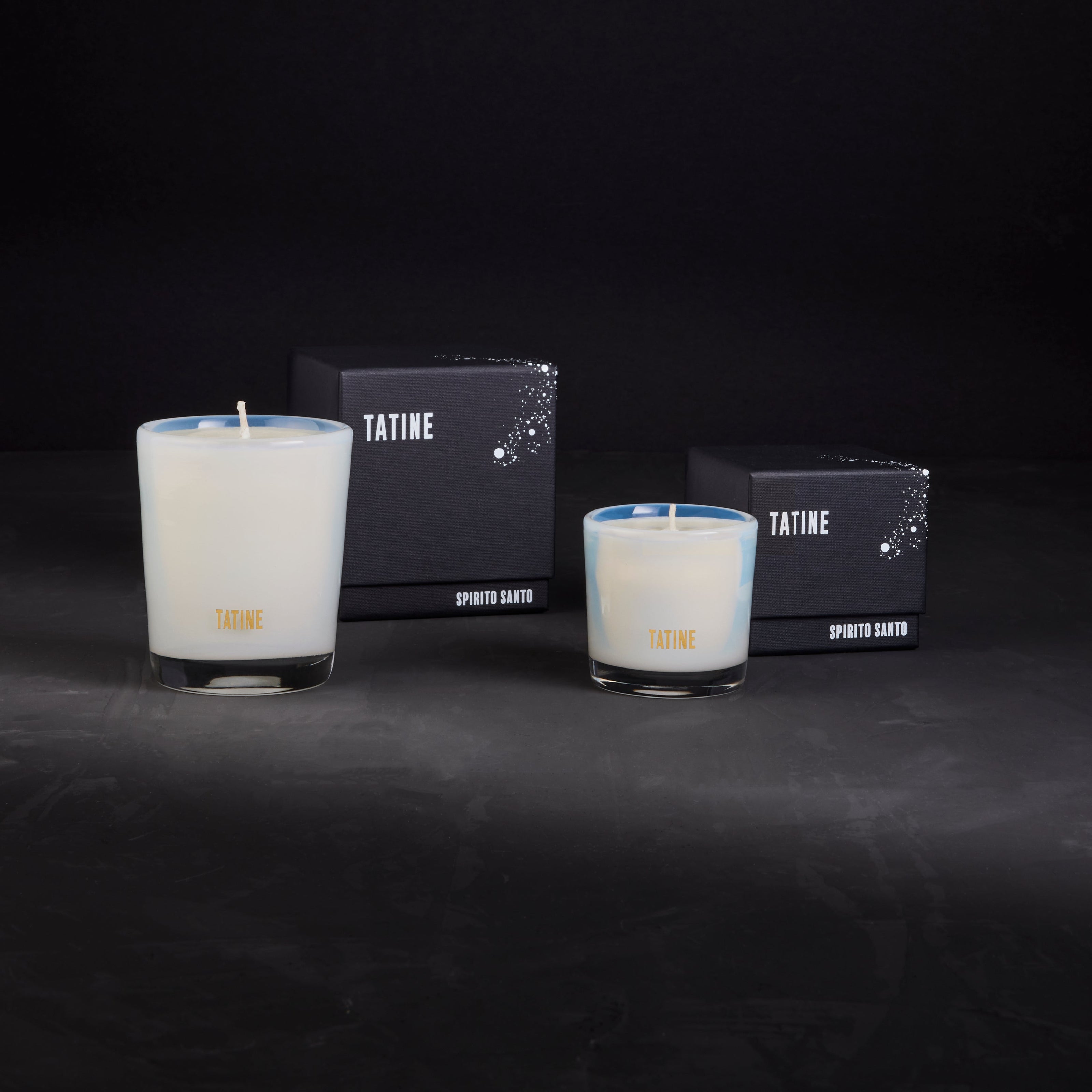 Tatine Stars Are Fire Classic Scented Candle with a warm, inviting glow in a clear glass container.